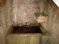 Imatge de la pica, el tub de ceràmica que sobeeixeix del dipòsit cisterna i el calaix per regar l’hort.